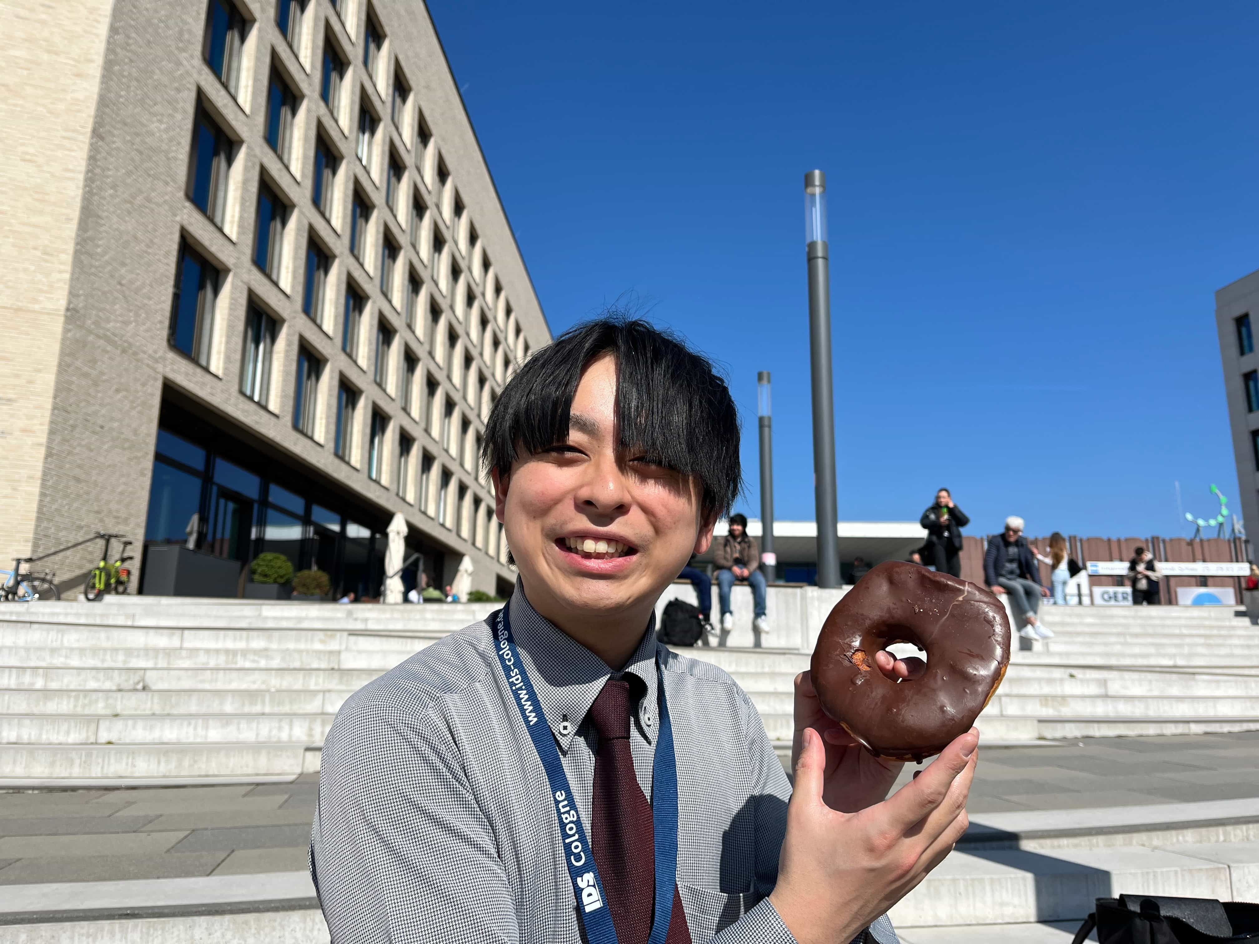 メッセ外で一息。ドーナッツが大きすぎて小顔効果？